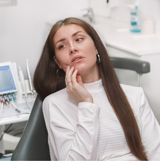 Woman in white sweater visiting emergency dentist