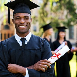 Man smiling in cap and gown