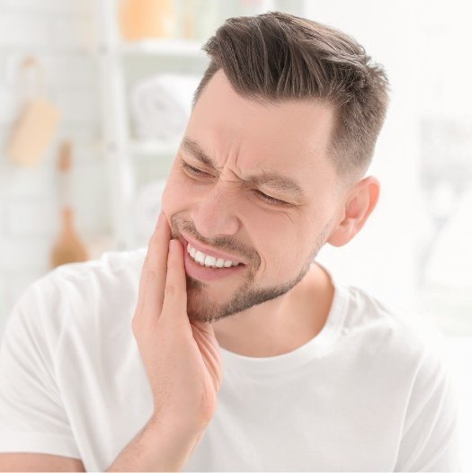 Man holding the side of his face in pain