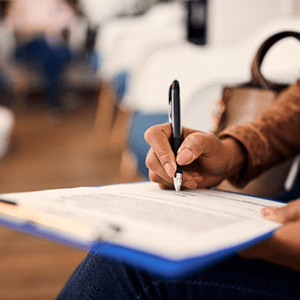 Woman filling out dental insurance form in lobby