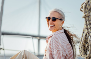 Mature woman enjoying the breeze and her cosmetic dental treatment